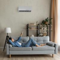 woman laying on couch using a an ac