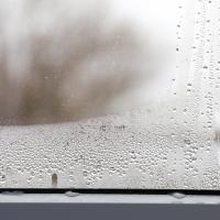 Water droplets on home window from indoor humidity
