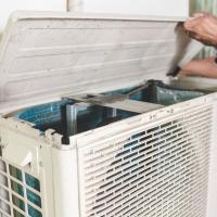 person working on an outdoor air conditioning unit