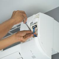 man fixing a heat pump head