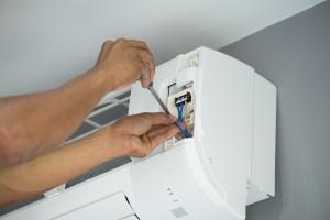 man fixing a heat pump head