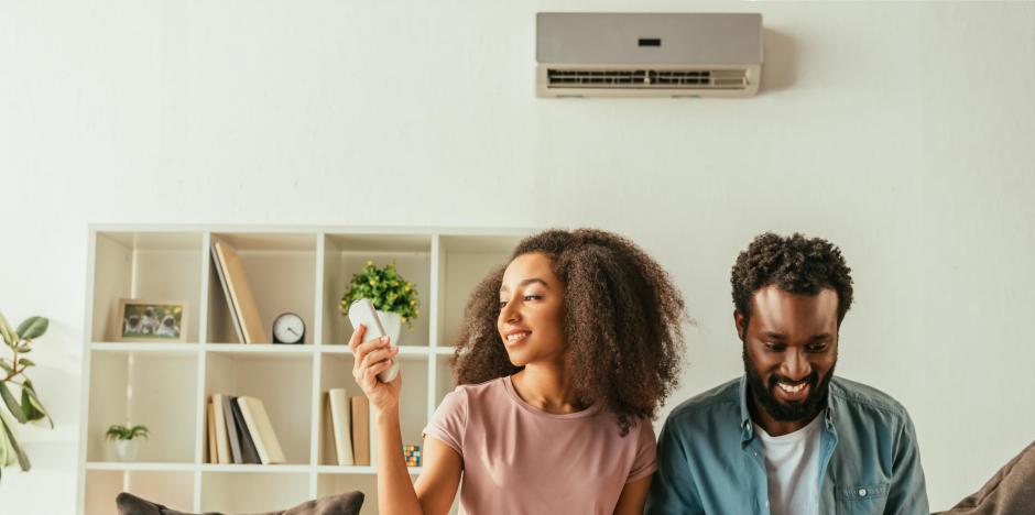 Couple sitting on couch in front of mini split Couple sitting on couch in front of mini split