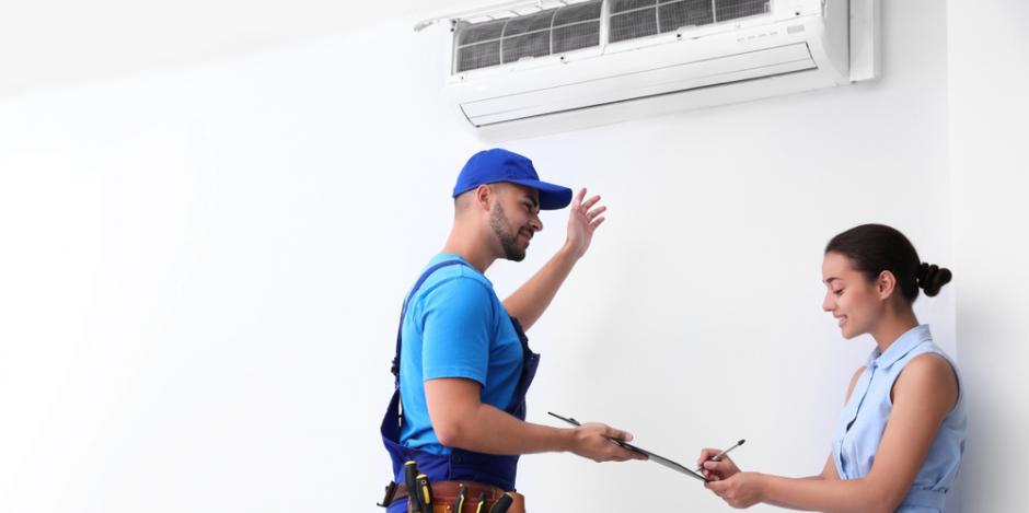 woman signing form from hvac technician installing new hvac unit inside home