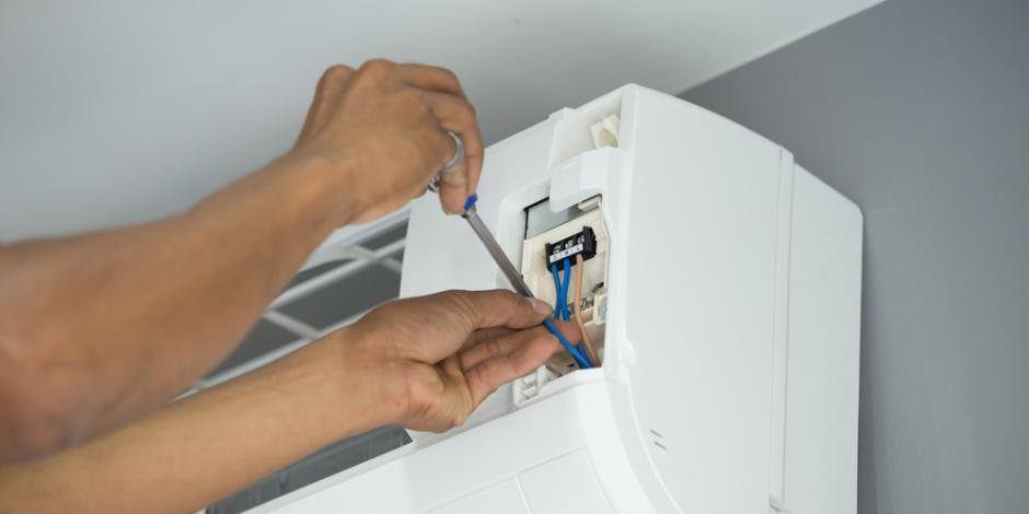 man fixing a heat pump head
